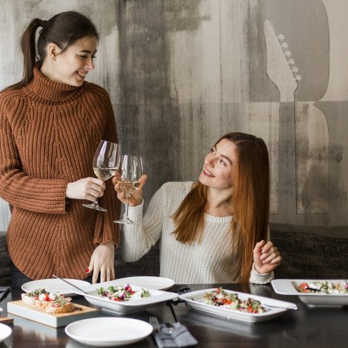 beautiful young women toasting glasses wine