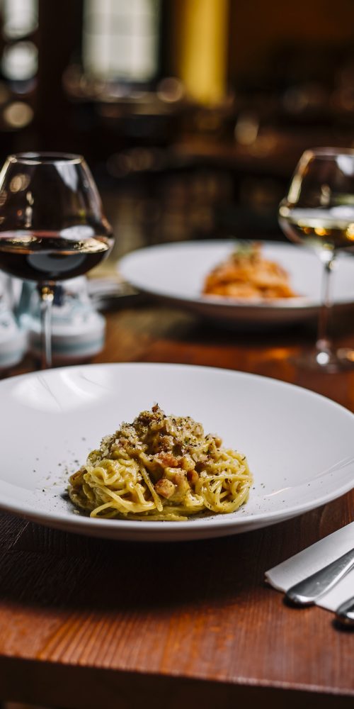spaghetti with meat in creamy sauce garnished with grated parmesan